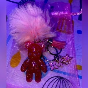 Pink pompom fluffy bear-shaped keychain with 3 charms.